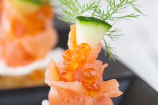 Smoked salmon and sour cream appetiser, garnished with dill. Close-up view